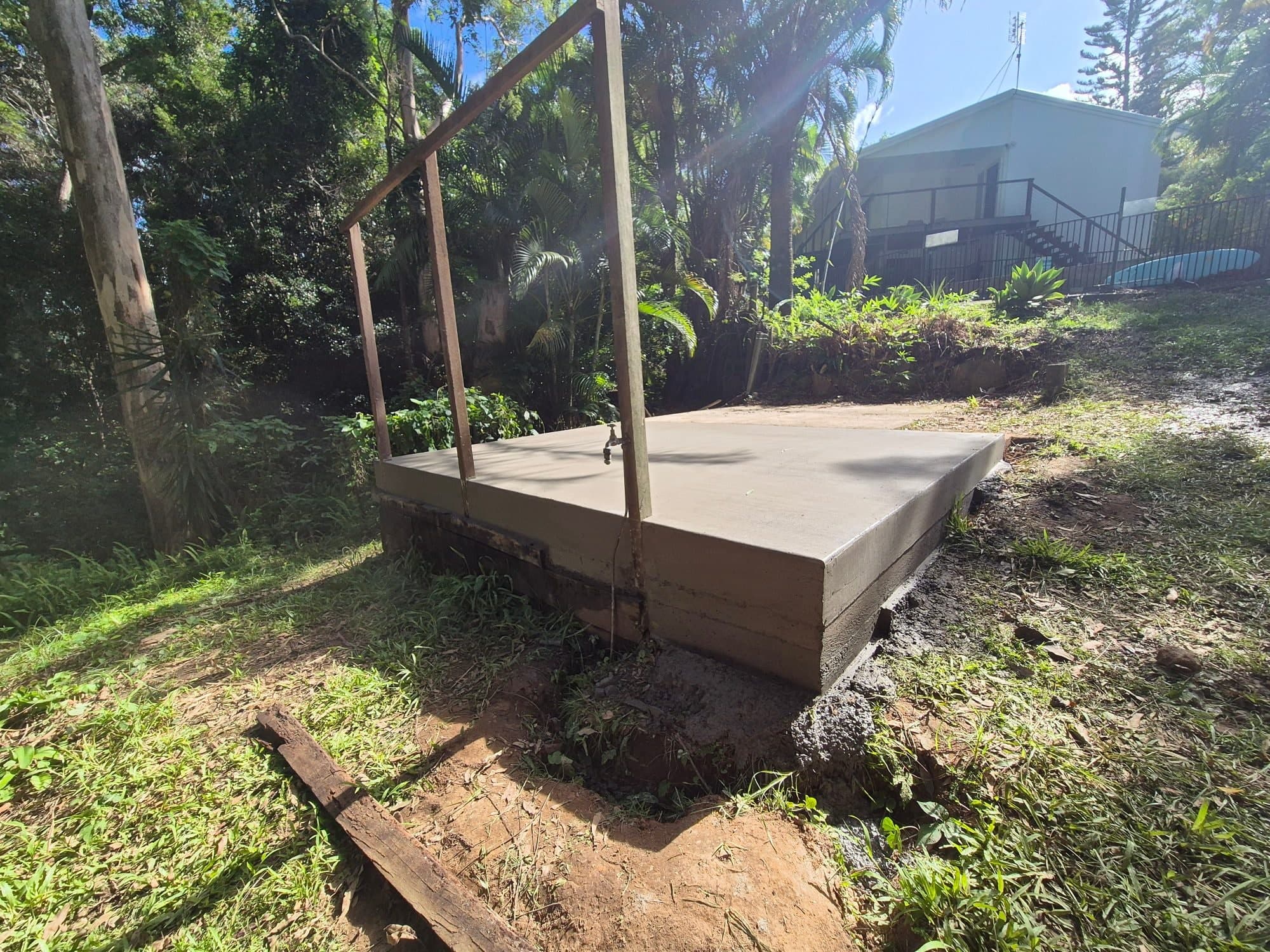 Concrete pad poured for a water tank in a yard