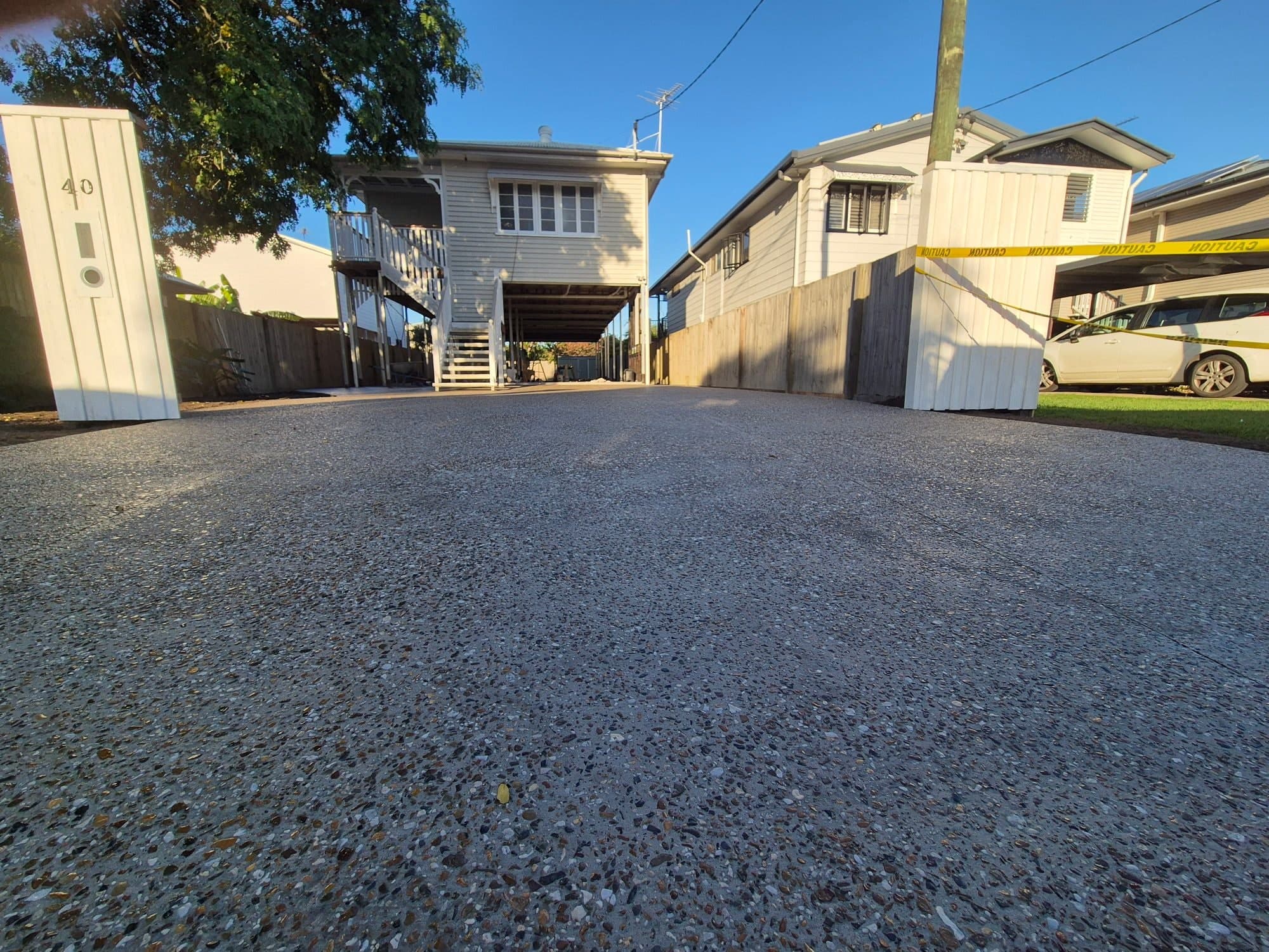 Finished exposed-aggregate concrete driveway and access area leading to a home